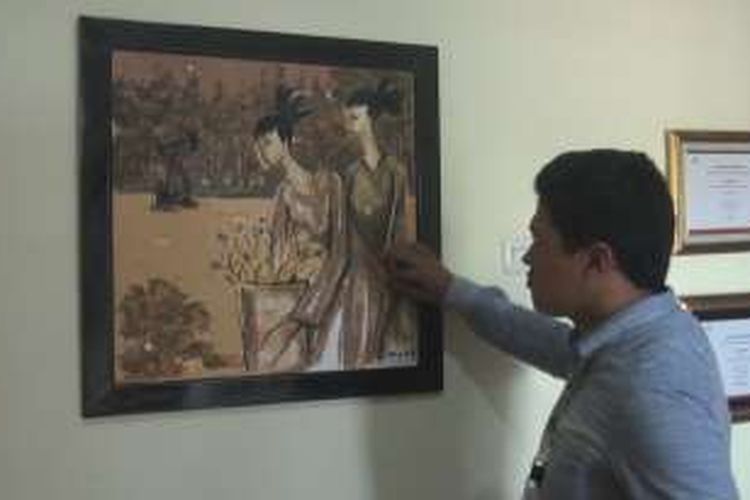 Salah seorang pengunjung tengah melihat lukisan tanah di Galeri Aang Sungkawa di sanggar merangkap rumahnya di Jalan RA Kartini, Kelurahan Sukajadi, Prabumulih.
