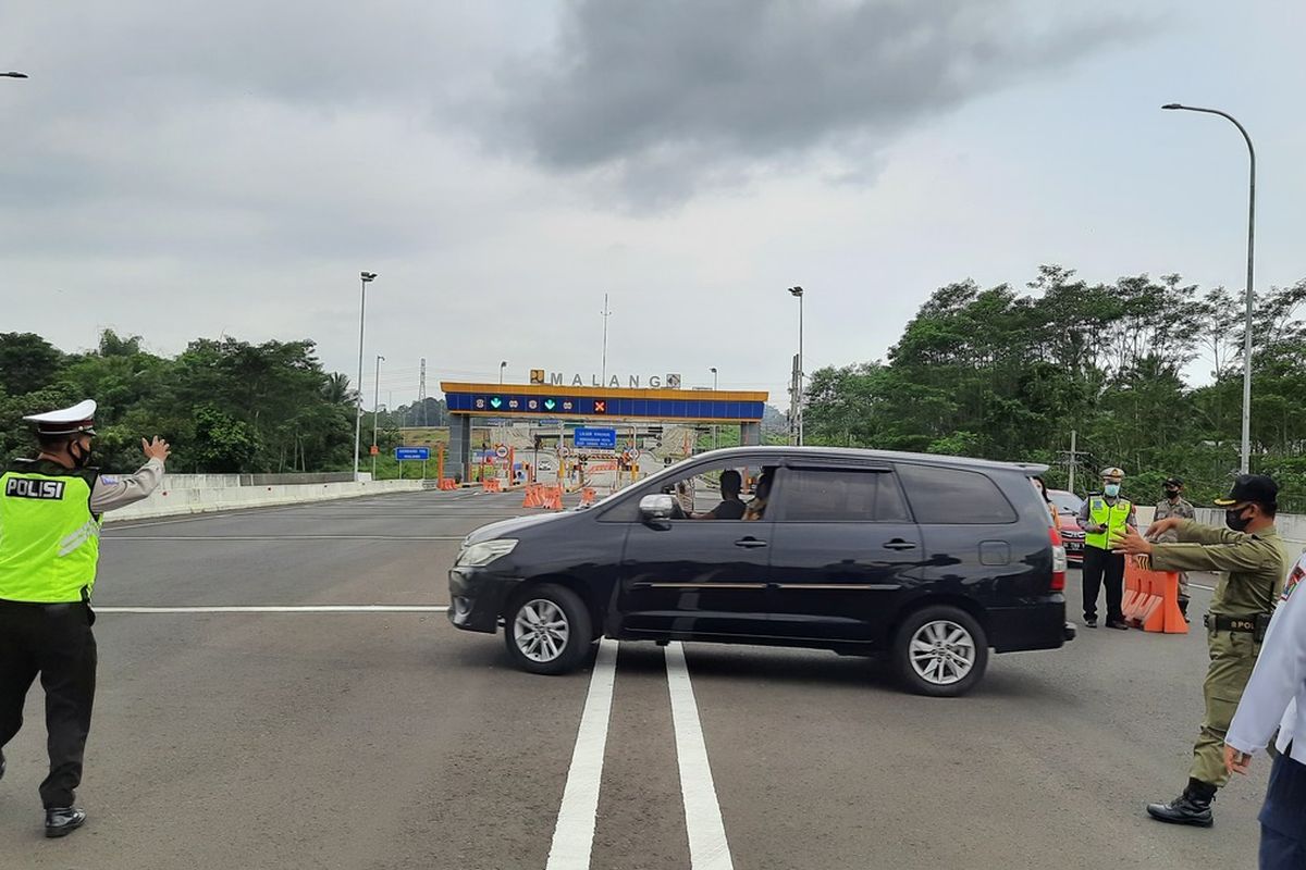 Petugas gabungan saat meminta kendaraan berplat luae kota untuk putar balik karena tidak memenuhi persyaratan untuk masuk Kota Malang terkait larangan mudik di Pintu Tol Malang, Jumat (7/5/2021)