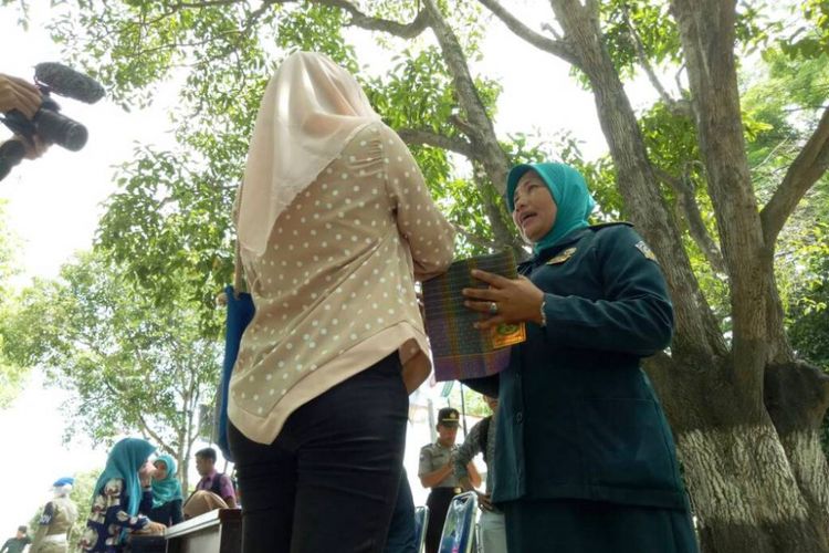 Polisi syariah membagikan sarung pada wanita berpakaian ketat di Taman Riyadah, Lhokseumawe, Selasa (16/5/2017)
