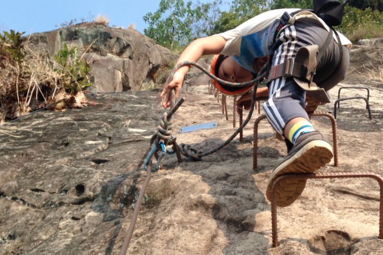 Bening memanjat tebing Gunung Parang, Purwakarta, menggunakan teknik yang disebut via ferrata atau naik menggunakan tangga baja, Minggu (2/7/2017)