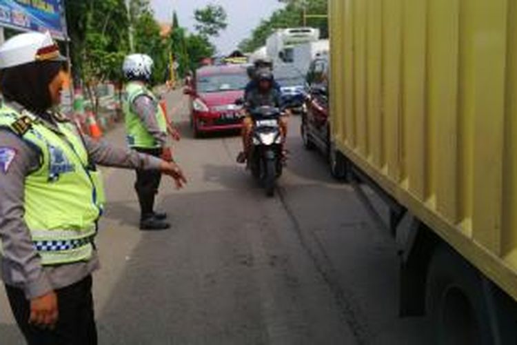 Petugas Satlantas Polres Brebes sedang mengatur arus lalu lintas di jalur Pantura Jalan Jenderal Soedirman Brebes, Jawa Tengah yang mengalami kemacetan.