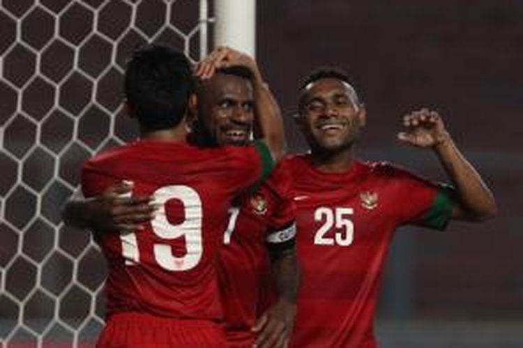 Pemain Indonesia Boaz Solossa (tengah) mendapat ucapan selamat dari rekannya, Titus Bonai (kanan), setelah berhasil mencetak gol ke gawang China pada babak kualifikasi Piala Asia 2015 di Stadion Utama Gelora Bung Karno, Jakarta, Selasa (15/10). Pertandingan berakhir imbang dengan skor 1-1.