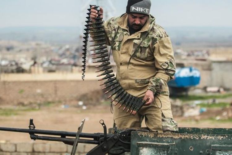 Seorang prajurit Irak tengah mempersiapkan senapan mesinnya sebelum menjalankan sebuah misi.