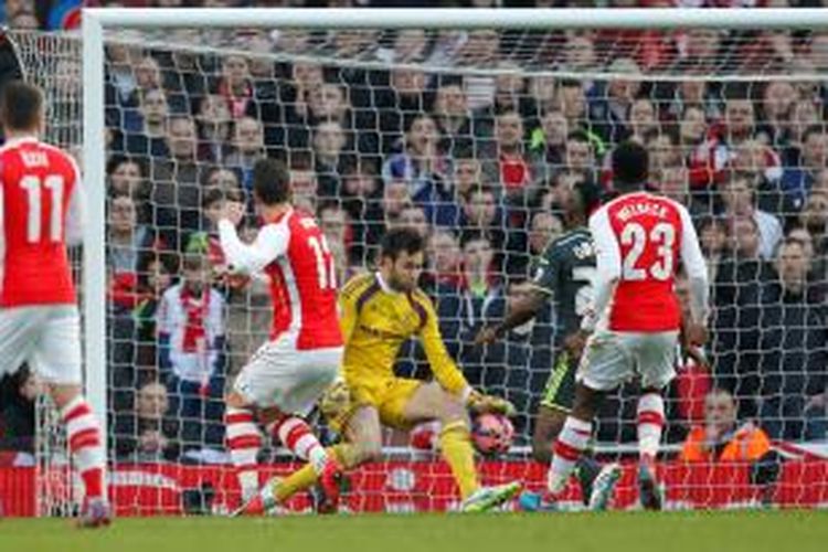 Striker Arsenal, Olivier Giroud, saat melepaskan tendangan yang berujung gol ke gawang Middlesbrough pada putaran kelima Piala FA di Emirates Stadium, Minggu (15/2/2015). 