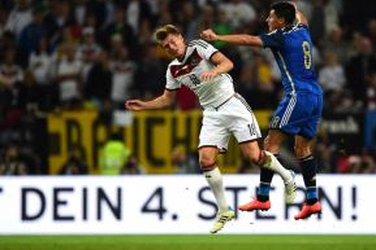 Gelandang Jerman Toni Kroos (kiri) berebut bola dengan gelandang Argentina, Enzo Perez, pada laga persahabatan, di Duesseldorf, Jerman, 3 September 2014.