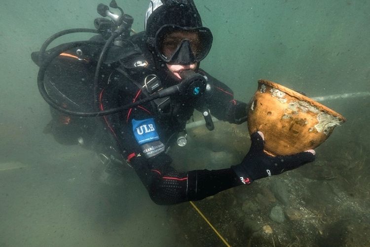 Foto tertanggal 14 Juni 2017 yang dirilis oleh Misi Teknis Belgia (MTB) pada April 2018, menunjukkan penyelam yang memegang artefak yang ditemukan di dasar Danau Titicaca di Bolivia.