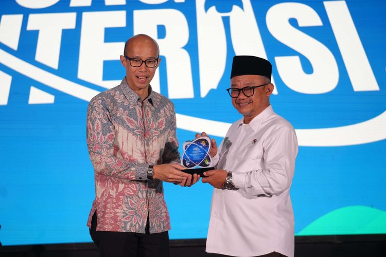 CEO of KG Media Andi Budiman (kiri) memberikan plakat kepada Menteri Pendidikan Dasar dan Menengah (Kemendikdasmen) Abdul Mu'ti saat hadir dalam acara perayaan HUT Kompas.com ke-30, Jagat Literasi yang digelar di Menara Kompas, Senin (15/9/2025)