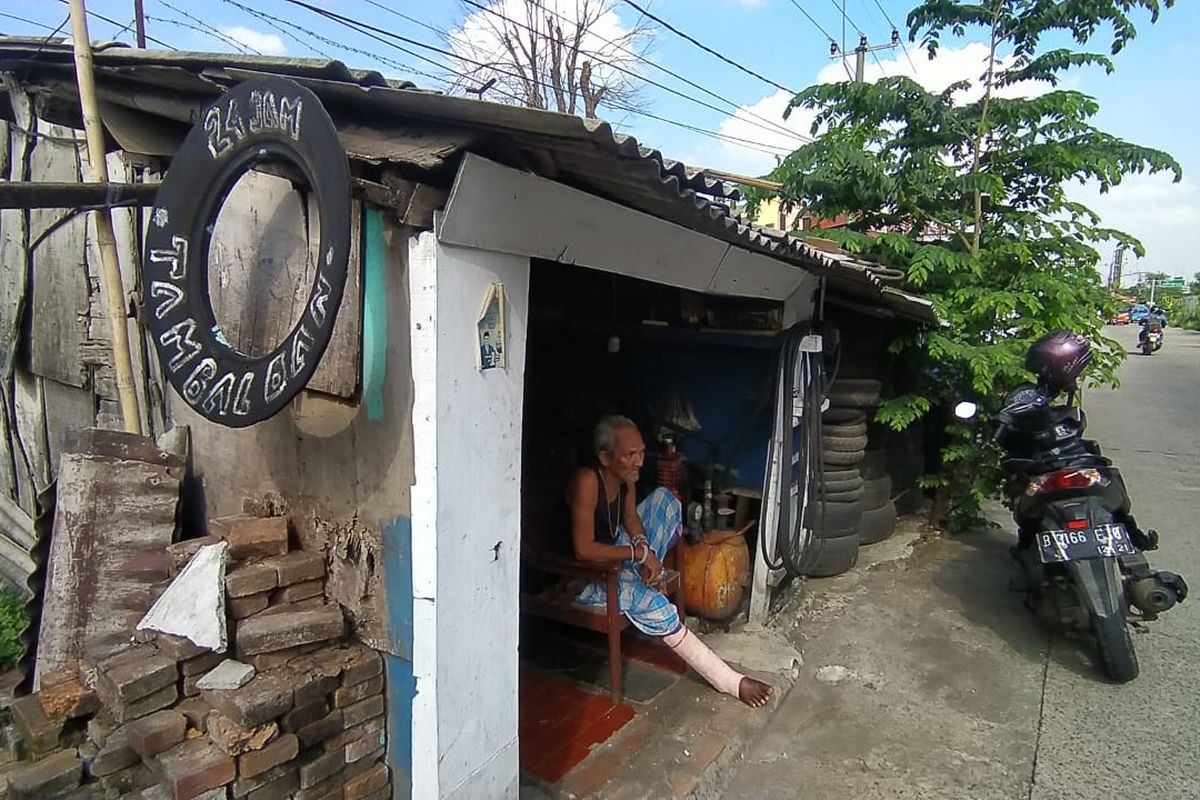 Mulyono (83) pada Kamis (5/8/2021) siang duduk termangu di rumah kecilnya yang juga berfungsi sebagai bengkel tambal ban di Jalan Gas Alam, Depok, Jawa Barat. Mulyono mengalami luka parah pada kaki kanannya akibat kecelakaan di jalan raya pada saat Lebaran 2021 lalu. Ia hanya mampu mengobatinya dengan singkong parut.