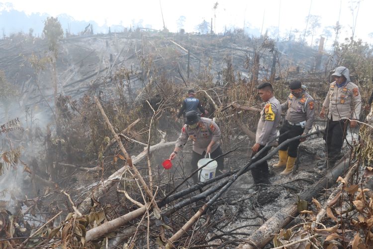 Kapolres Inhu AKBP Dody Wirawijaya bersama anggotanya dengan peralatan seadanya memadamkan api karhutla di Desa Siambul, Kecamatan Batang Gangsal, Kabupaten Inhu, Riau, Jumat (6/10/2023).
