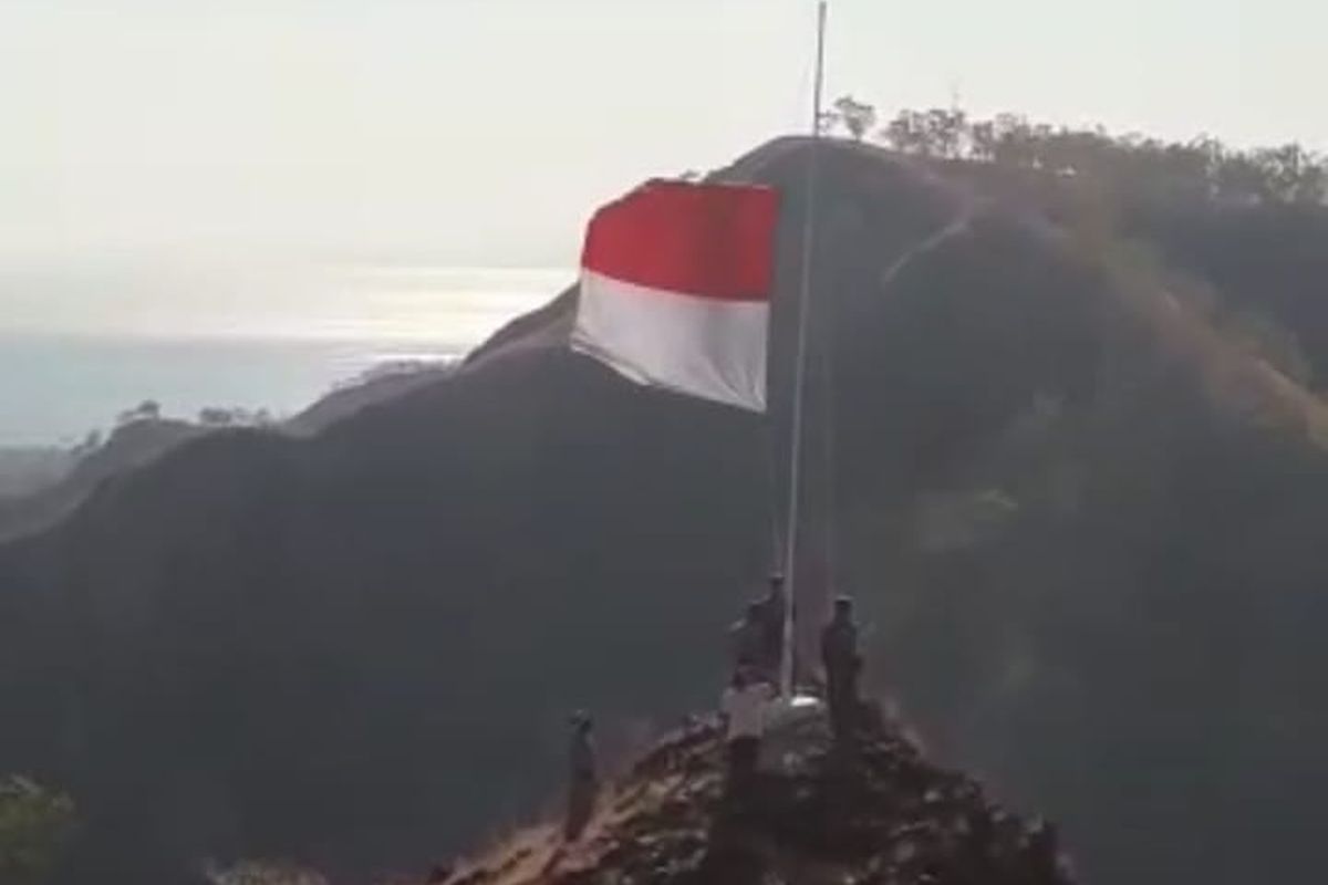 Puluhan pemuda dan pemudi  di Desa Manufonu, Kecamatan Insana Utara, Kabupaten Timor Tengah Utara (TTU), Nusa Tenggara Timur, bersama anggota TNI dan Polri, menggelar kegiatan pengibaran bendera merah putih dalam rangka HUT ke-67 RI di bukit terjal yang berbatasan dengan Negara Timor Leste, Selasa (17/8/2021)