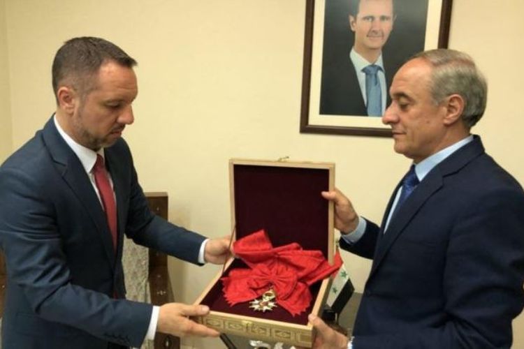 Perwakilan Pemerintah Suriah (kiri) ketika mengembalikan penghargaan Legiun Kehormatan yang diberikan Perancis kepada Presiden Bashar al-Assad melalui Kedutaan Besar Romania di Damaskus.