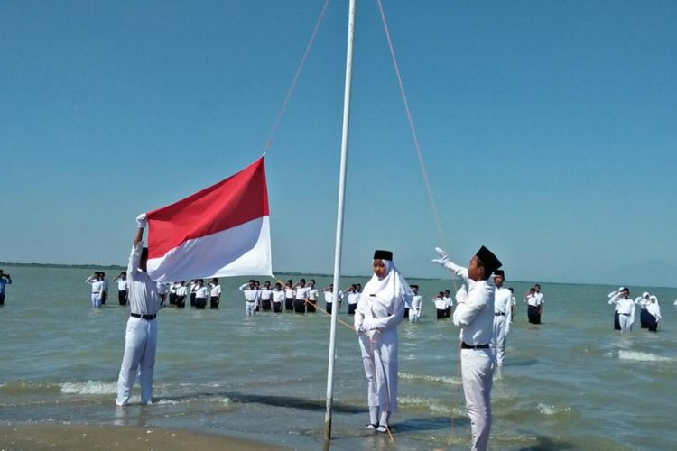 Petugas pengibar bendera menaikan sang merah putih,  dalam upacara peringatan HUT Kemerdekaan RI ke 73 di Pantai Onggojoyo,  Kecamatan Wedung,  Kabupaten Demak,  Jateng,  Jumat (17/8/2018)