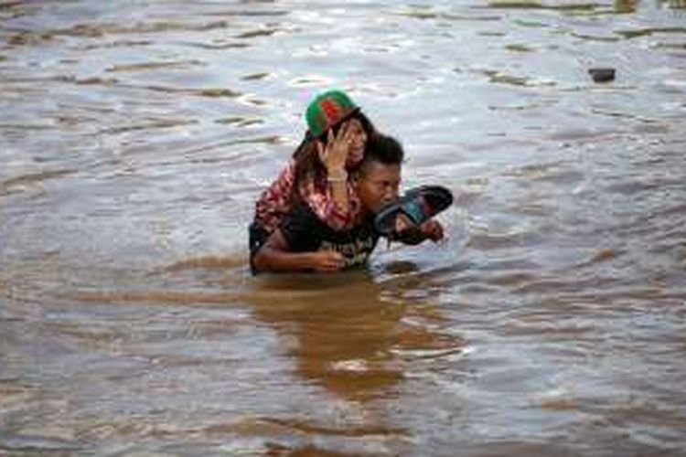 Warga melintasi Jalan Raya Dayeuhkolot- Banjaran, Baleendah, Kabupaten Bandung, Jawa Barat, yang terendam banjir, Minggu (13/3/2016). Selain merendam ribuan rumah warga di sejumlah kecamatan, banjir akibat luapan Sungai Citarum ini melumpuhkan memutus akses Dayuehkolot-Banjaran sehingga perekonomian warga pun terganggu. Warga mengatakan jika banjir kali ini lebih besar dari banjir yang biasa melanda.



Kompas/Rony Ariyanto Nugroho (RON)

13-03-2016