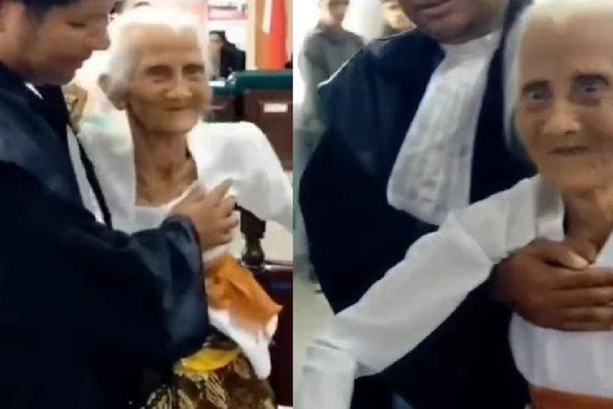 Nenek Ni Nyoman Reja saat mendatangi persidangan kasus pemalsuan silsilah. Ia tampak dipapah saat masuk ruang sidang. 
