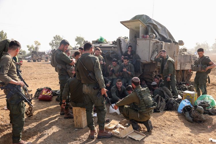 Tentara Israel bersama kendaraan militernya berjaga di dekat perbatasan Jalur Gaza pada 3 Desember 2023 di tengah perang Israel-Hamas.