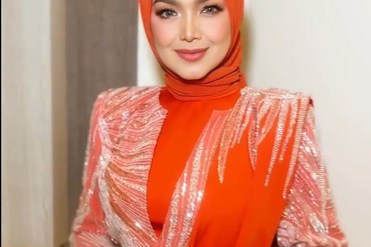 Siti Nurhaliza tampil memukau di Pestapora 2025 dengan hijab oranye terang, setelan berpayet, dan makeup soft glam yang elegan.