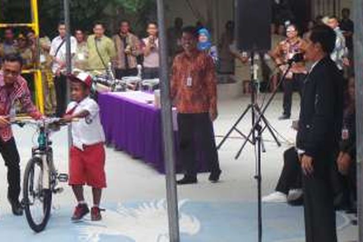 Presiden Joko Widodo memberikan sepeda kepada anak SD YPKP Bonaventura, Sentani, Jayapura, Senin (17/10/2016).