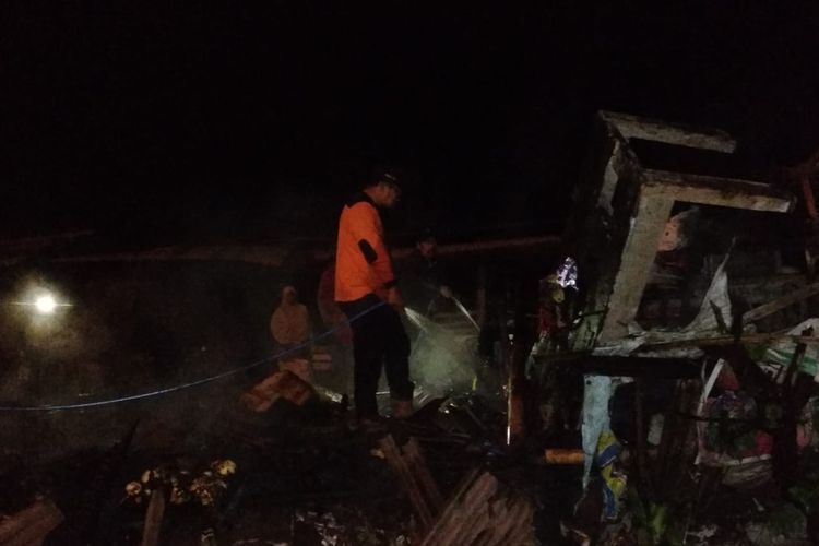 Seorang relawan berupaya memadamkan api yang membakar kios d Pasar Mlati