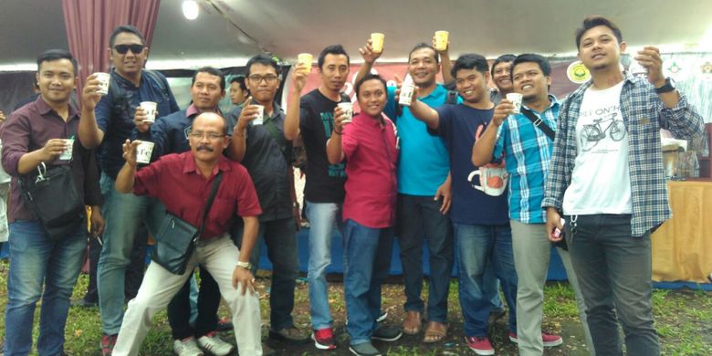 Pengunjung Robusta Fiesta menunjukkan gelas kopi robusta di Kampus Universitas Jember, Jawa Timur, Jumat (11/10/2017).