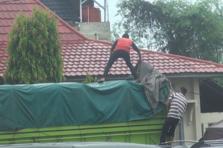Seorang pekerja terlihat menutup bak truk dengan terpal di depan Kantor KPU Ogan Ilir Sumsel. Truk itu sendiri berisi muatan logisitk pilkada gubernur dan wakil gubernur Sumsel tahun 2018