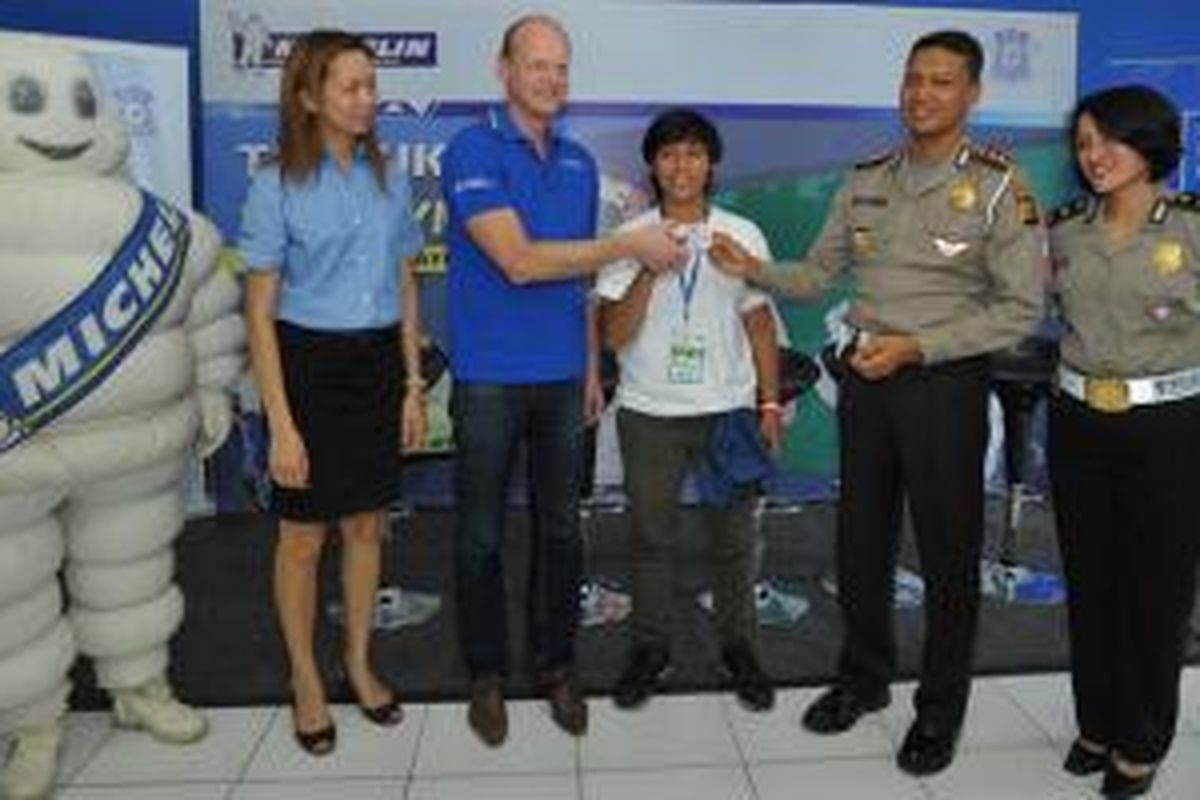 (Dari ki-ka) Head of Public Affairs PT Michelin Indonesia Nora Guitet, Country Director PT Michelin Indonesia Jean-Charles SIMON, Wadirlantas Polda Metro Jaya AKBP Bakharuddin Muhammad Syah, Kasi Sarana Angkutan Jalan Dikyasa Polda Metro Jaya Kompol Endah Susilowati tengah memberikan SIM bagi salah satu peserta dari SMU 48 Jakarta Timur yang berhasil lulus pada ujian SIM hari ini di Taman Lalu Lintas, Cibubur.