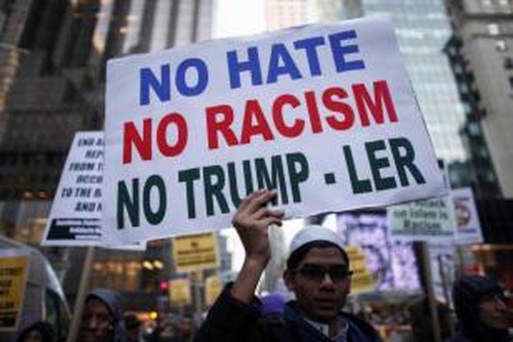 Remaja muslim memegang poster saat ikut berunjuk rasa mengecam Donald Trump di New York, 20 Desember 2015. Capres AS Donald Trump dari Partai Republik menyerukan semua pencegahan semua muslim masuk ke AS.