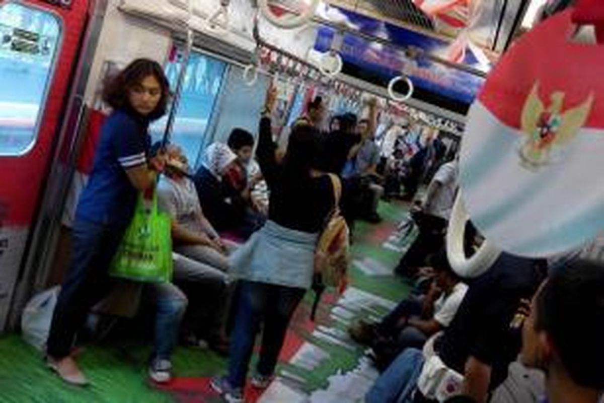 Suasana di salah satu gerbong KRL Commuter Line jurusan Bogor-Jakarta Kota yang dipenuhi ornamen bertema kemerdekaan, Senin (17/8/2015).               