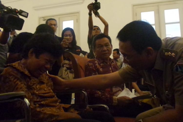 Gubernur DKI Jakarta Basuki Tjahaja Purnama menenangkan Saurlan Pasaribu, warga yang sakit struk, di Balai Kota DKI, Senin (8/5/2017). 