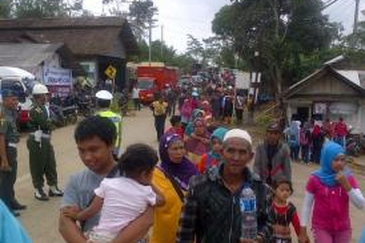 Ratusan warga berjalan meninggalkan lokasi longsor di pertigaan menuju dusun Jemblung, Desa Sampang, Banjarnegara, Jawa Tengah, Minggu (14/12/2014).
