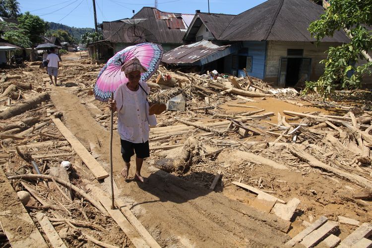 Warga melintas di area banjir bandang dan longsor di Kelurahan Huta Nabolon, Kecamatan Tukka, Kabupaten Tapanuli Tengah, Sumatera Utara, Rabu (3/12/2025). Berdasarkan data dari BNPB hingga Rabu (3/12) jumlah korban meninggal akibat  bencana banjir bandang dan longsor di Provinsi Aceh, Sumatera Utara, dan Sumatera Barat sebanyak 807 jiwa, 647 jiwa orang hilang dan korban luka sebanyak 2.600 jiwa. 
