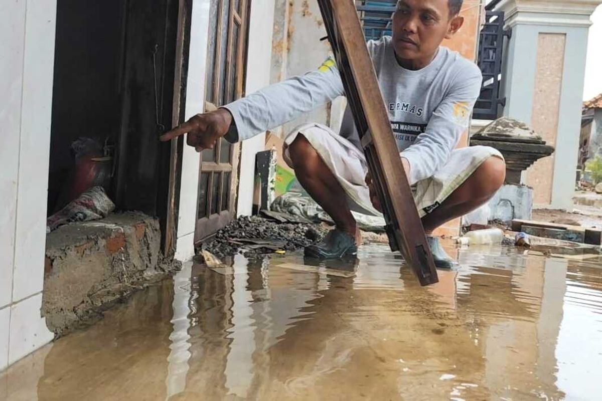 Warga menunjukkan jendela yang sudah tinggi rata dengan lantai untuk membendung banjir rob, di Desa Ambulu, Kecamatan Losari, Kabupaten Cirebon, Jawa Barat, pada Kamis (9/1/2025) siang.