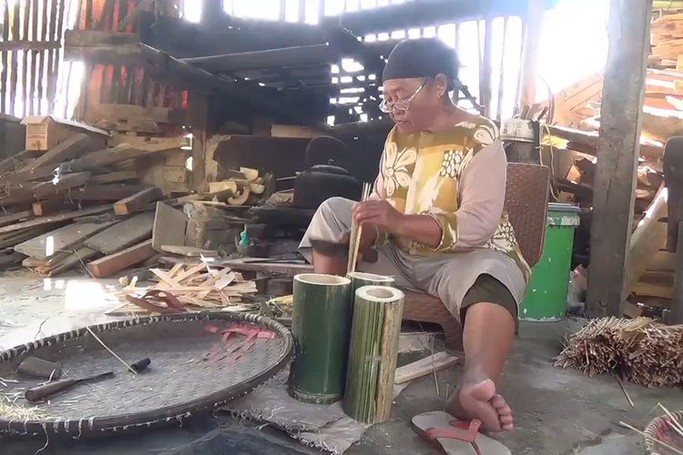 Karmini (63) salah seorang wanita pembuat tusuk sate di Deda Kutawaringin, Kecamatan Kutawaringin, Kabupaten Bandung, Jawa Barat, saat tengah melakukan aktifitas memotong bambu untuk dibuat tusuk sate, Kamis (13/6/2024)