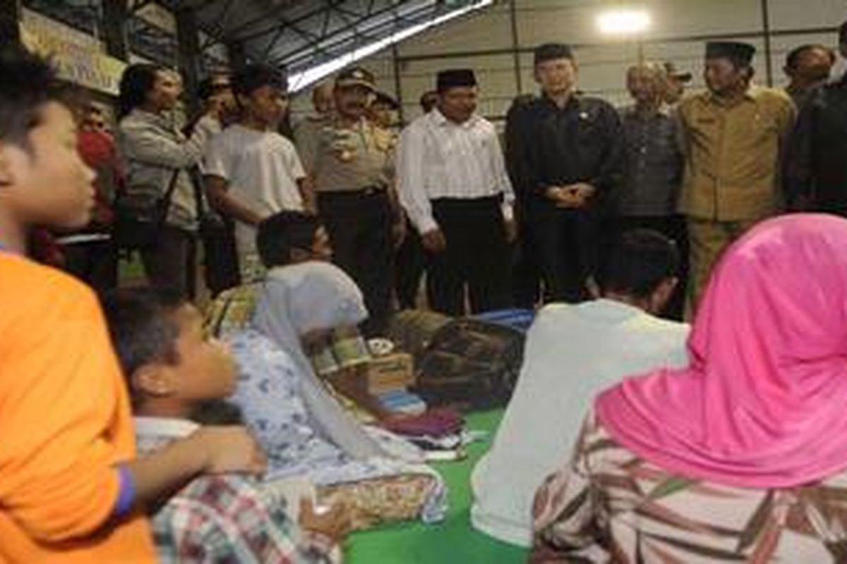 Menteri Agama Surya Dharma Ali, Kepala Kepolisian RI Jenderal Timur Pradopo , Panglima TNI Laksamana Agus Suhartono dan Kepala Kepolisian Daerah Jawa Timur Inspektur Jenderal Hadiatmoko. mengunjungi pengungsi korban kerusuhan di tempat pengungsian di Hall tennis Indoor, Kabupaten Sampang, Jawa Timur, Senin 27/8/2012). kerusuhan yang melibatkan dua kelompok warga menyebabkan  satu orang tewas, 205 warga mengungsi, dan sejumlah rumah dibakar. 