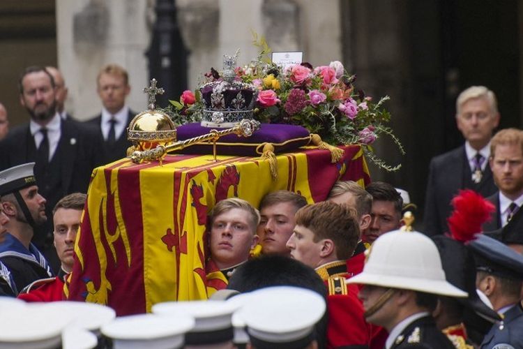 Pemakaman Ratu Elizabeth II. Anggota 1st Battalion Grenadier Guards menggotong peti mati sang ratu yang dibalut simbol Royal Standard menuju kereta meriam di luar Westminster Hall, Istana Westminster, London, Senin (19/9/2022). Indonesia diundang ke pemakaman ratu dan Dubes RI Desra Percaya datang sebagai perwakilan.