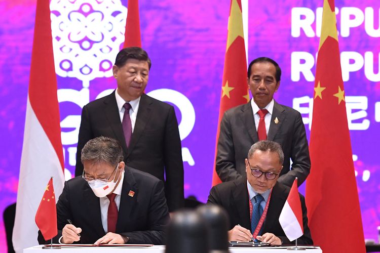 Indonesia's Trade Minister Zulkifli Hasan (right, seated) and his Chinese counterpart Wang Wentao (left, seated) sign an agreement on Further Expanding and Deepening Bilateral Economic and Trade Cooperation (BETC) on the sidelines of G20 Summit on Wednesday, November 16, 2022 in the Indonesian resort island of Bali. Present to witness the signing ceremony was Indonesia's President Joko Widodo (right, standing) and China's President Xi Jinping (left, standing). 