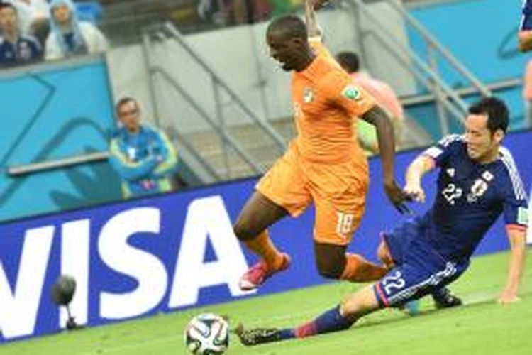 Gelandang Pantai Gading, Yaya Toure, saat berusaha melewati pemain Jepang pada pertandingan Grup C Piala Dunia 2014 di Itaipava Arena Pernambuco, Recife, Sabtu atau Minggu (15/6/2014) pagi WIB. Pantai Gading menang 2-1 pada laga tersebut. 