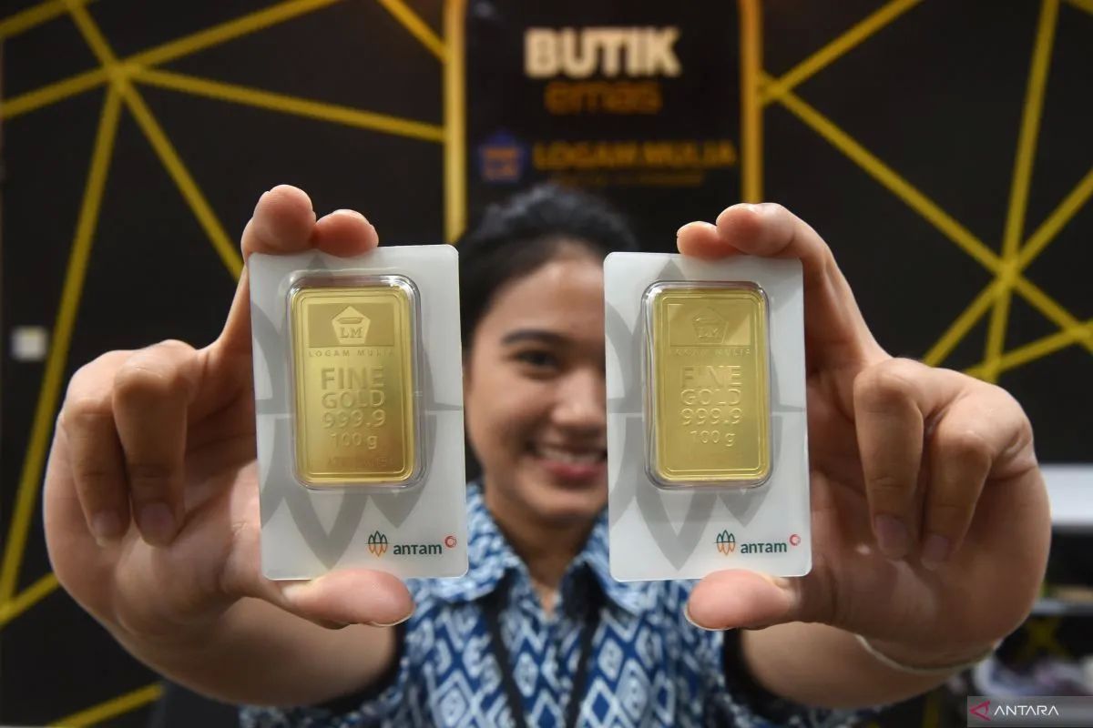 Pegawai menunjukkan emas Antam yang dijual di Butik Emas. Cek daftar harga emas Antam hari ini.