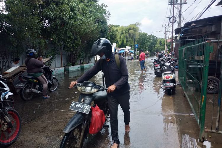 Pengendara motor yang memaksa melintasi area banjir, akhirnya mogok di tengah jalan, Jalan  Menteng Raya Tegal Alur Jakarta Barat, Rabu (19/1/2022).