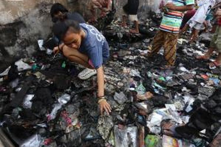 Warga korban kebakaran di Tambora, Jakarta Barat, memeriksa barang-barang di kawasan rumahnya yang telah hangus, Minggu (27/9/2015).