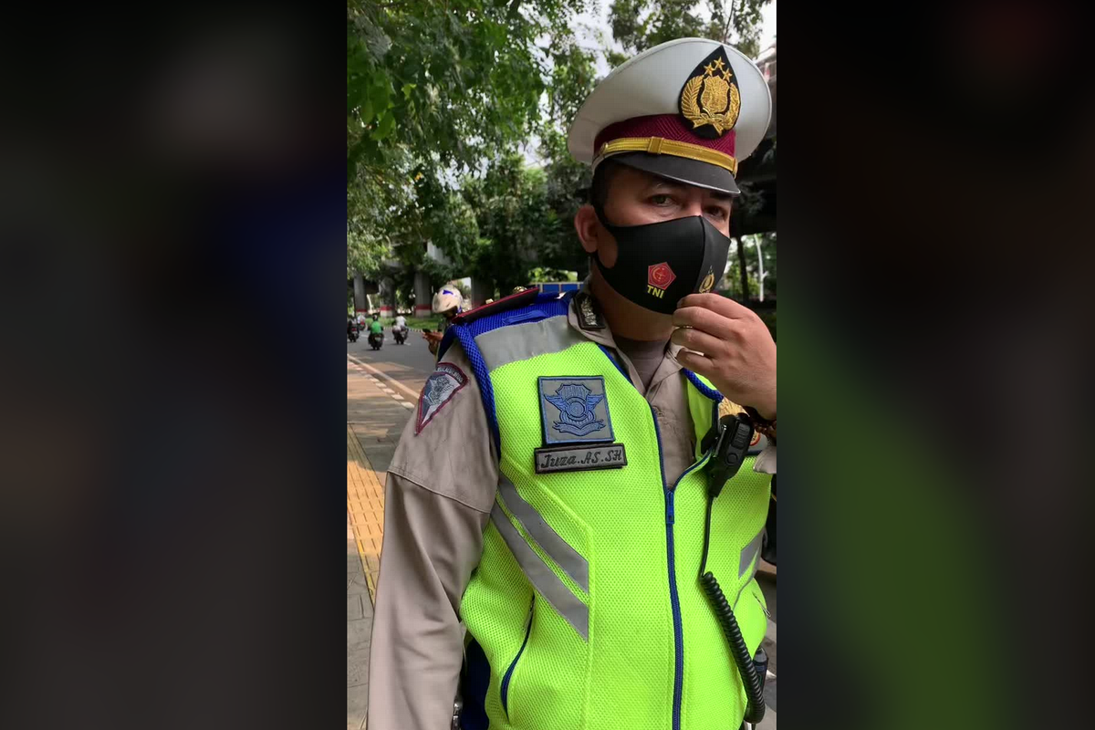 Video viral di media sosial memperlihatkan cekcok antara polisi lalu lintas dengan pengendara sepeda motor. 