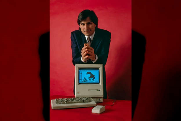 Pendiri Apple Steve Jobs berpose dengan PC Macintosh 128K.