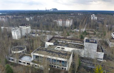 Pemandangan kota hantu Pripyat dengan tempat perlindungan yang menutupi reaktor yang meledak di pembangkit nuklir Chernobyl di latar belakang, Ukraina, Kamis, 15 April 2021. 