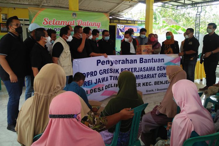 Jajaran DPRD dan pengurus REI Jatim Komisariat Gresik, saat menyalurkan bantuan kepada warga terdampak banjir air luapan Kali Lamong di Balai Desa Delik Sumber, Kecamatan Benjeng, Rabu (1/12/2021).