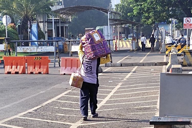 Para portir atau kuli panggul saat menunggu penumpang turun di depan ruang tunggu sementara Gapura Surya Nusantara Pelabuhan Perak Surabaya