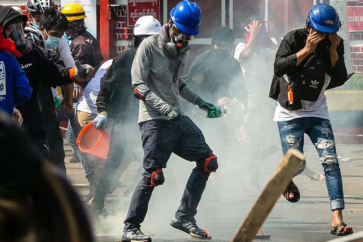 Para pengunjuk rasa berlari setelah gas air mata ditembakkan oleh polisi yang mencoba membubarkan mereka selama demonstrasi menentang kudeta militer di Yangon, Myanmar, Minggu (28/2/2021). Sedikitnya 18 orang tewas dan 30 lainnya terluka dalam aksi demonstrasi di Myanmar pada 28 Februari, serta disebut sebagai hari paling berdarah dalam serentetan aksi protes menentang kudeta militer.