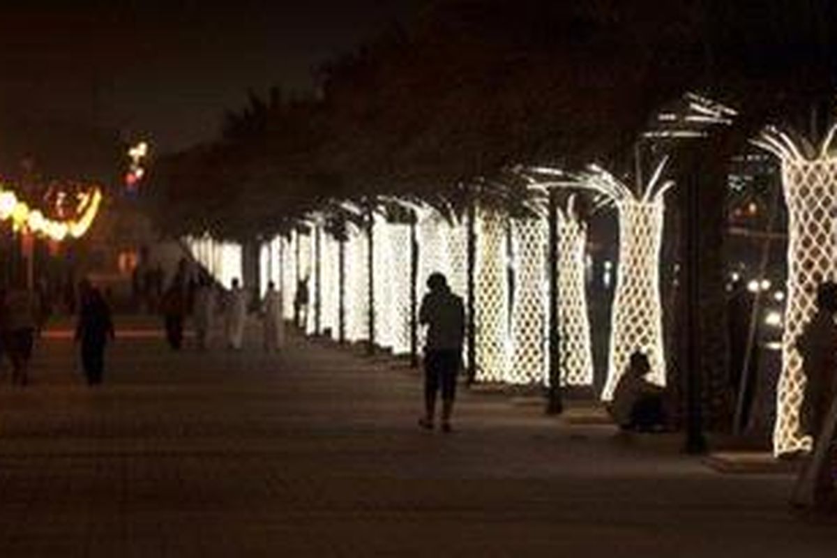 Warga Arab Saudi di Kota Riyadh berjalan di Jalan Raja Abdullah yang didekorasi dengan lampu-lampu menjelang perayaan Idul Fitri yang jatuh pada Selasa (30/8/2011) waktu setempat.