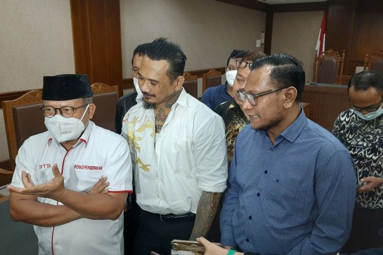 Jerinx SID didampingi tim kuasa hukumnya usai menghadiri sidang lanjutan perkara pengancaman terhadap Adam Deni di Pengadilan Negeri (PN) Jakarta Pusat, Senin (22/2/2022). Pada kesempatan tersebut, Jerinx membacakan 7 poin dalam nota pembelaannya dengan keinginan utamanya bisa dibebaskan. 