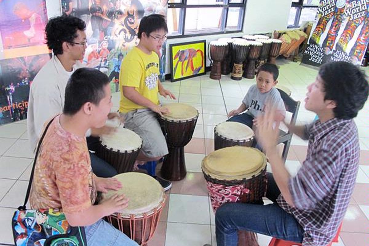 Relawan muda  mengajar anak-anak berkebutuhan khusus memainkan jimbe di Bandung, Jawa Barat.