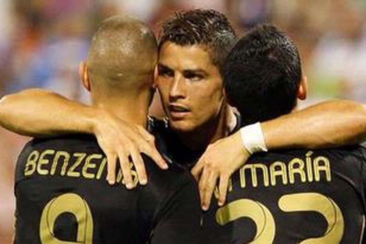 Gelandang Real Madrid, Cristiano Ronaldo memeluk penyerang Karim Benzema (kiri) dan pemain sayap Angel Di Maria (kanan), usai mencetak gol kedua (dari tiga) ke gawang Real Zaragoza, pada laga pembuka Liga BBVA 2011-2012, Minggu (28/8/2011).