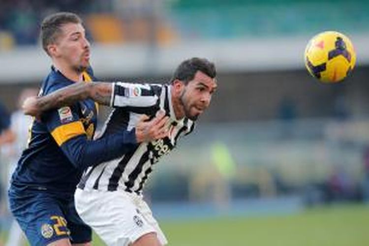 Striker Juventus, Carlos Teves (kanan), saat berebut bola dengan bek Hellas Verona, Fabrizio Cacciatore (kiri), pada lanjutan Serie-A di Stadion Marc' Antonio Bentegodi, Minggu (9/2/2014). Kedua tim bermain imbang 2-2 pada laga tersebut. 